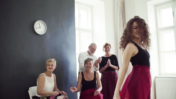 A group of senior people attending dancing class with dance teacher. Slow motion.