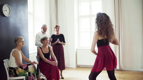 A group of senior people attending dancing class with dance teacher. Slow motion.