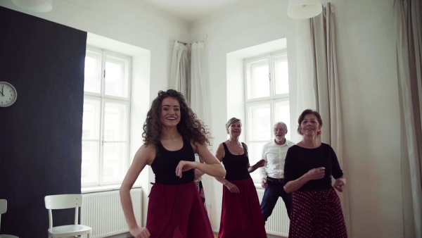 A group of senior people attending dancing class with dance teacher. Slow motion.