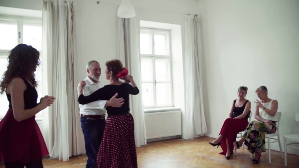 A group of senior people attending dancing class with dance teacher. Slow motion.