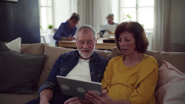 Senior couple using tablet in community center club, technology in everyday life concept. Slow motion.