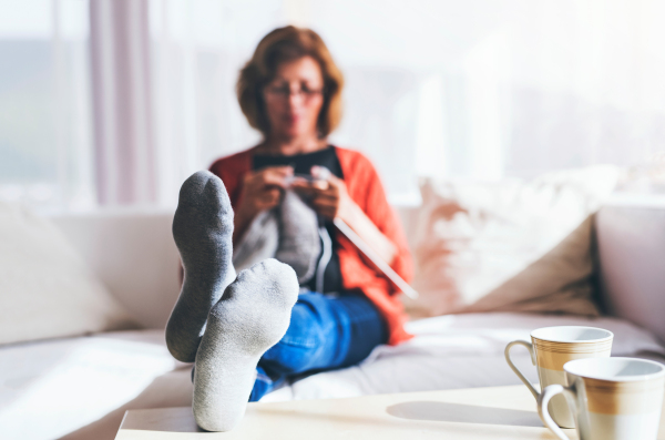 Happy senior woman relaxing at home, knitting.