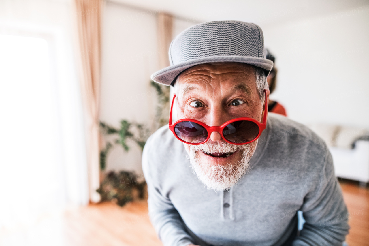 Crazy senior man having fun at home.