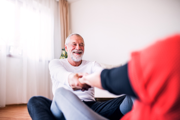 Happy senior couple doing exercise at home.