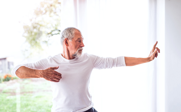 Active senior man doing exercise at home.