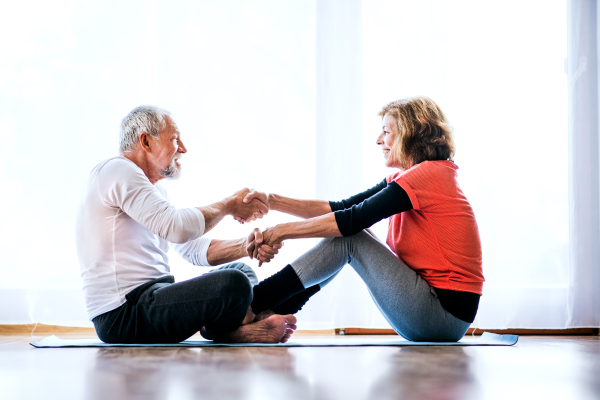 A happy senior couple doing exercise at home.