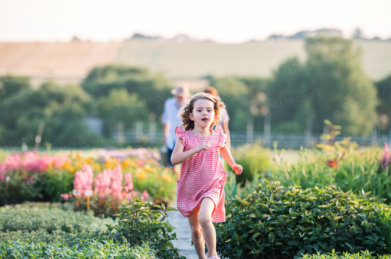 A front view of small girl running in the backyard garden.