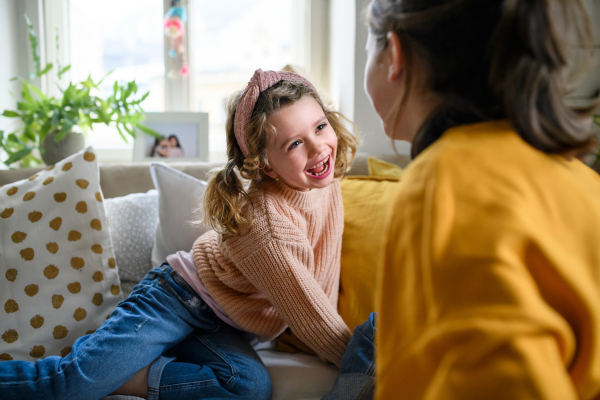 Cheerful sisters indoors at home, playing and having fun. Lockdown concept.