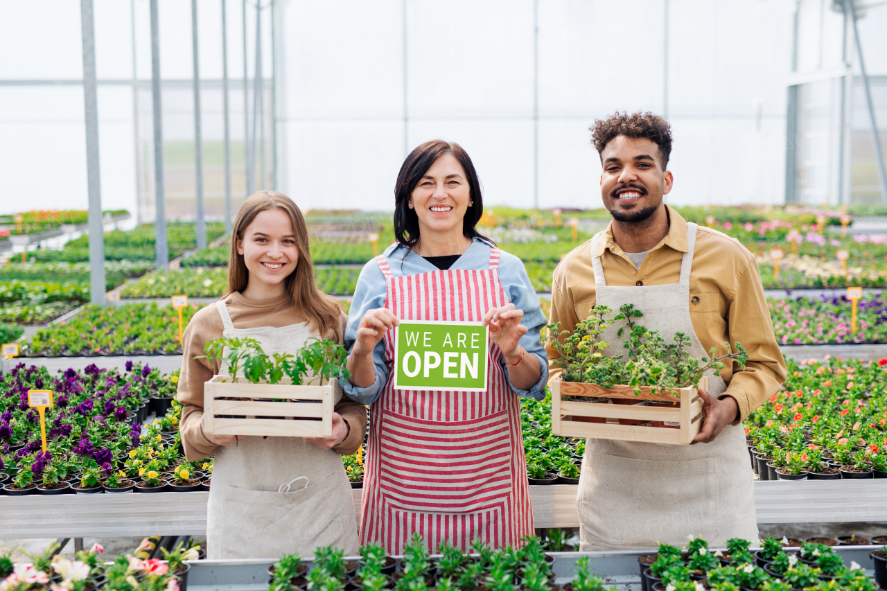 Portrait of people working and looking at camera in greenhouse in garden center, store open after lockdown.