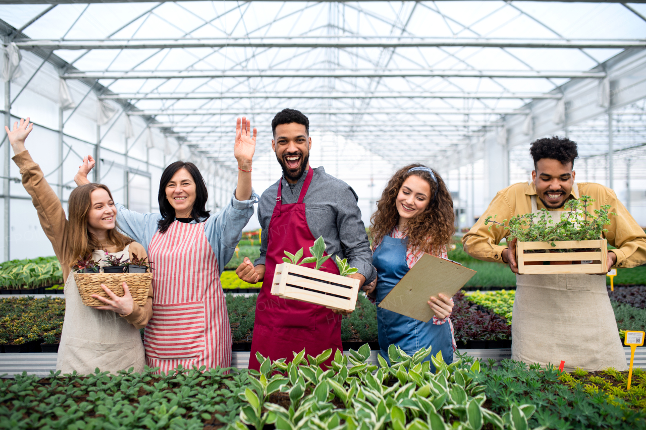 A portrait of people having fun in greenhouse in garden center, looking at camera.