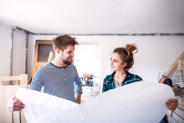 Small business of a young couple. Man and woman worker in the carpenter workroom.