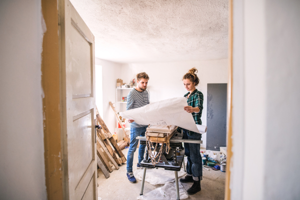 Small business of a young couple. Man and woman worker in the carpenter workroom.