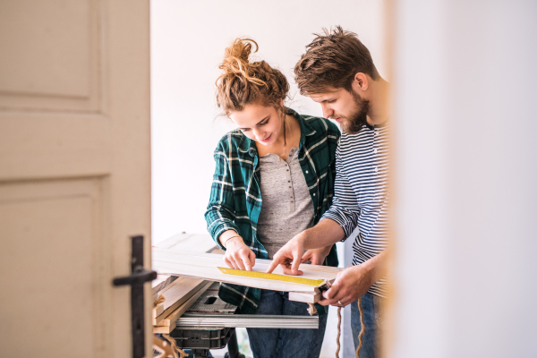 Small business of a young couple. Man and woman worker in the carpenter workroom.