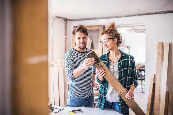 Small business of a young couple. Man and woman worker in the carpenter workroom.