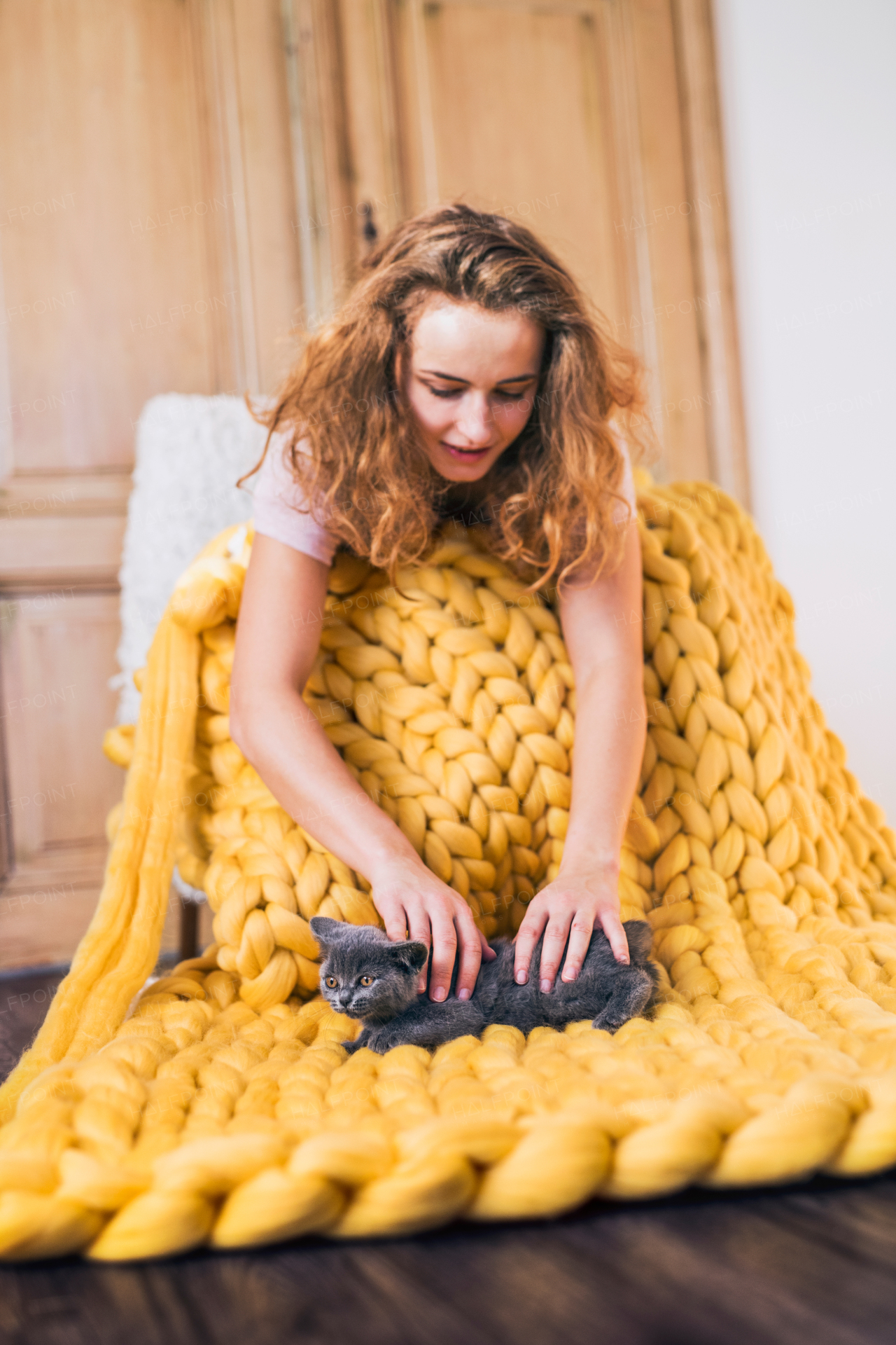 Small business of a young woman. Young woman hand-knitting a woollen blanket.