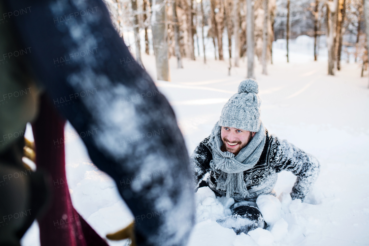 Two young friends having fun in snow outdoors in winter, midsection.