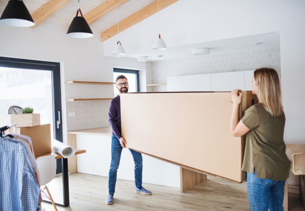 A young happy couple furnishing new house, a moving in new home concept.