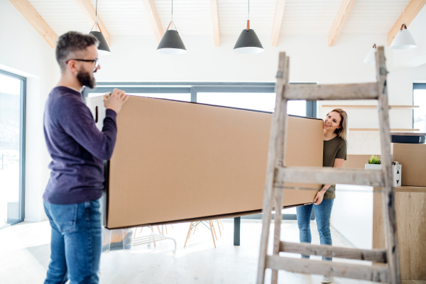 A young happy couple furnishing new house, a moving in new home concept.