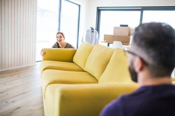 A young happy couple furnishing new house, a moving in new home concept.