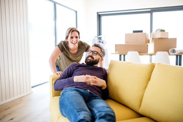 A young happy couple furnishing new house, a moving in new home concept.