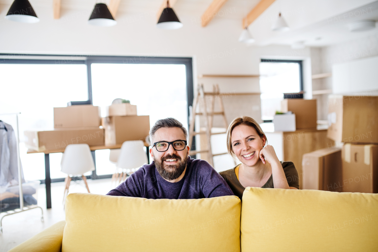 A portrait of young happy couple furnishing new house, a moving in new home concept.