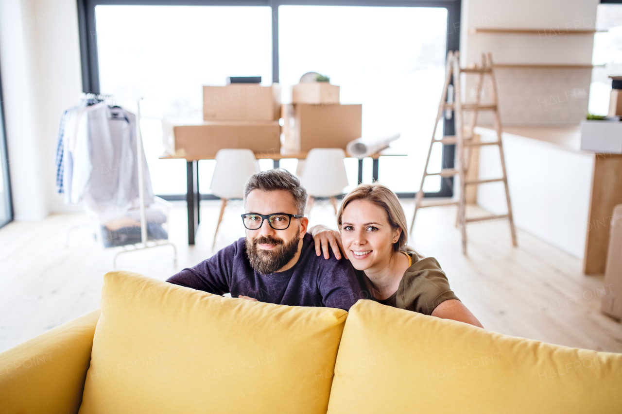 A portrait of young happy couple furnishing new house, a moving in new home concept.