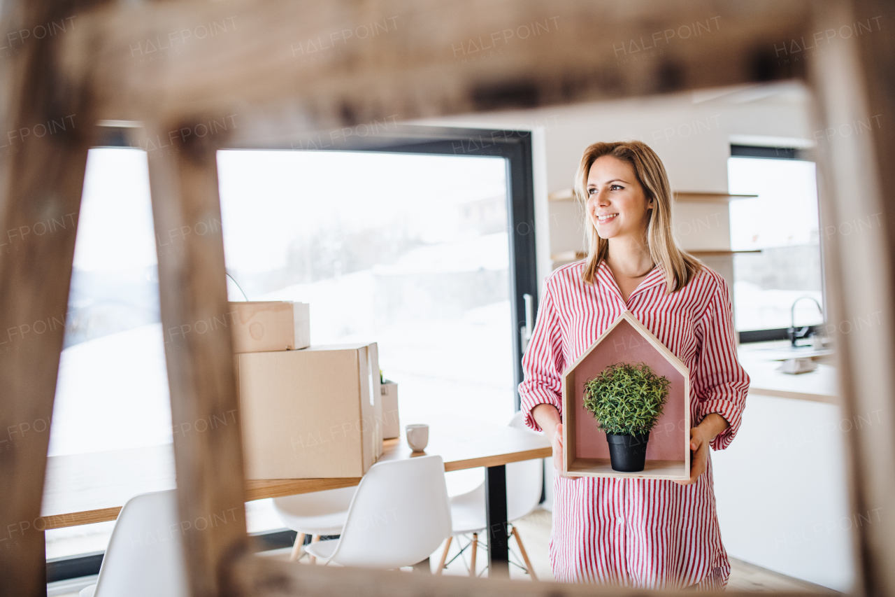 A young woman with plant moving in new home, a concept. Copy space.