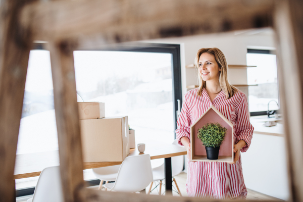 A young woman with plant moving in new home, a concept. Copy space.