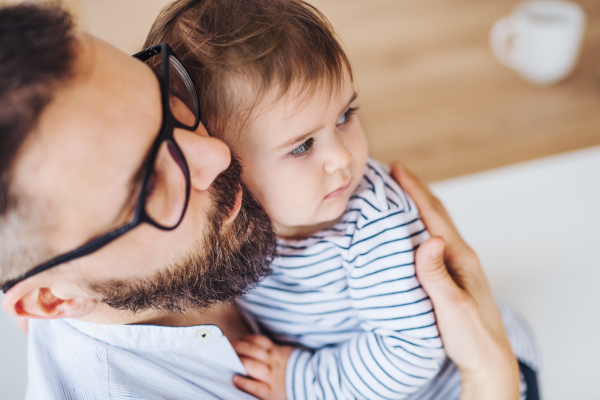 A top view portrait of mature father with a toddler girl standing indoors.