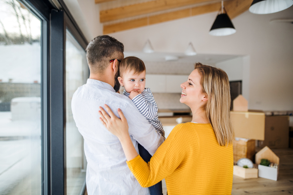 A happy young family with a toddler girl moving in new home.