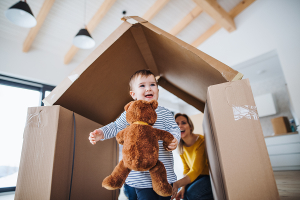 A portrait of happy young family with a toddler girl, moving in new home concept.