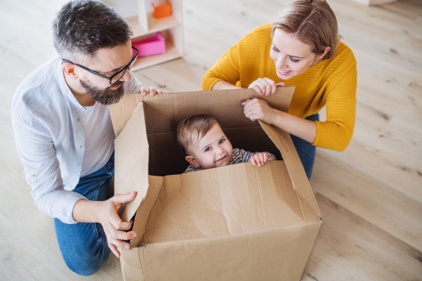 A top view of happy young family with a toddler girl moving in new home.