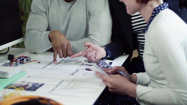 A group of young businesspeople talking in office, start-up concept.