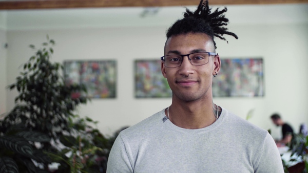 A portrait of young mixed race businessman in office, looking at camera.