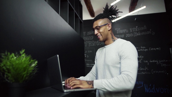 A young businessman with laptop in office, working. Slow motion.