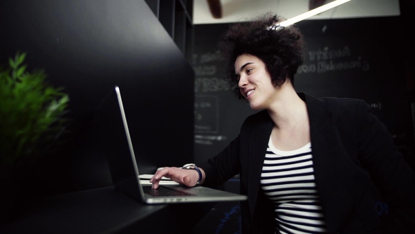 A young businesswoman with laptop in office, working. Slow motion.