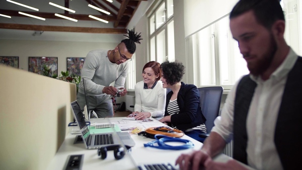 A group of young businesspeople talking in office, start-up concept. Slow motion.