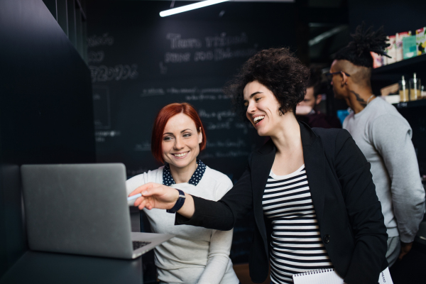 A group of young businesspeople using laptop in office, start-up concept.