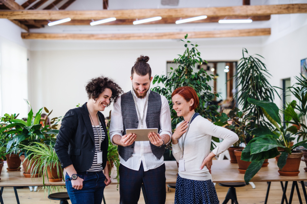 A group of young businesspeople using tablet in office, start-up concept.