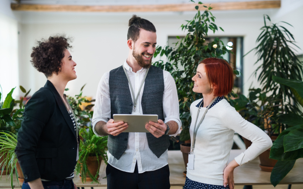 A group of young businesspeople using tablet in office, start-up concept.