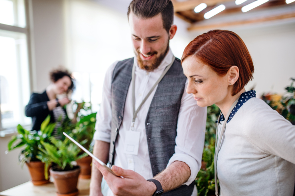 Two young businesspeople using a tablet in office, start-up concept.