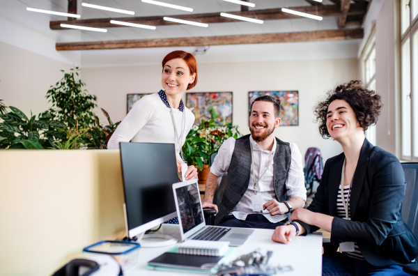 A group of young businesspeople using laptop in office, start-up concept.