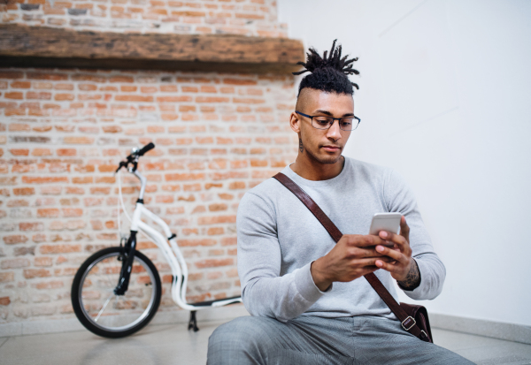 A young mixed race businessman using telephone in office.