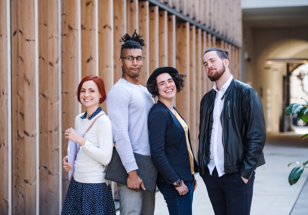 Group of young businesspeople standing outdoors in courtyard, having fun. A start-up concept.