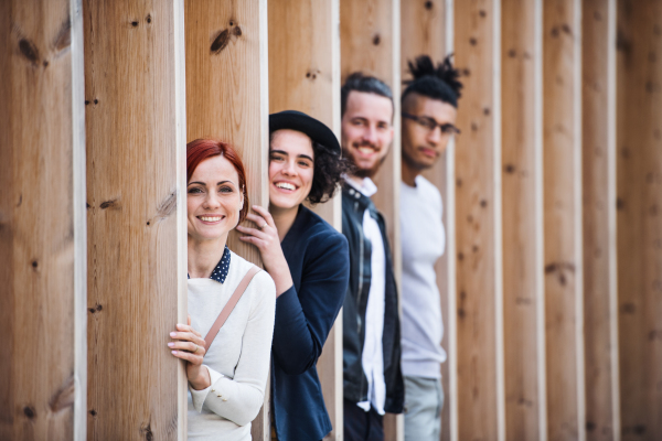 Group of young businesspeople standing outdoors in courtyard, having fun. A start-up concept.