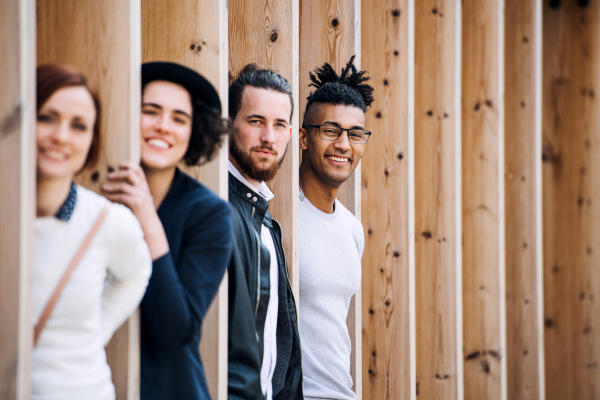 Group of young businesspeople standing outdoors in courtyard, having fun. A start-up concept.