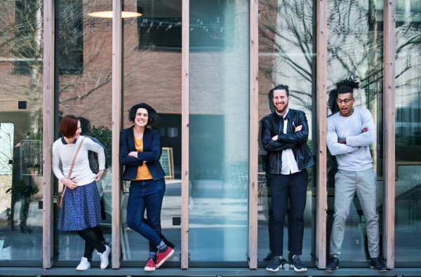 Group of young businesspeople standing outdoors in courtyard, arms crossed. A start-up concept.