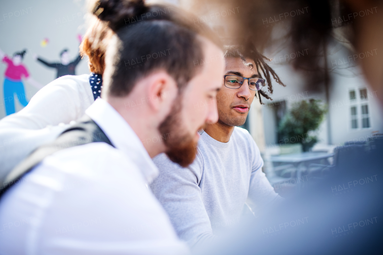 A close-up of young businesspeople in courtyard, talking. A start-up concept.