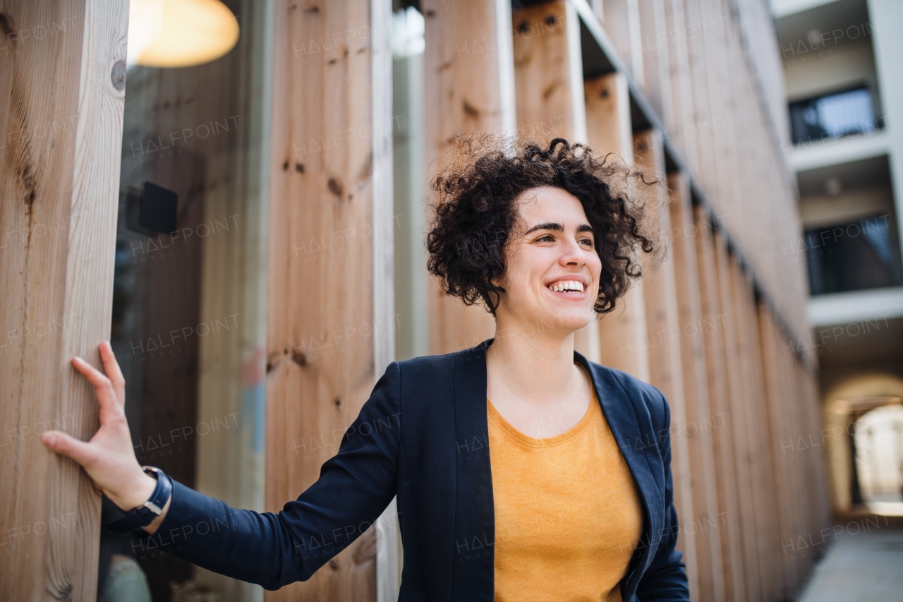 A happy young business woman standing outdoors, resting. Start-up concept.