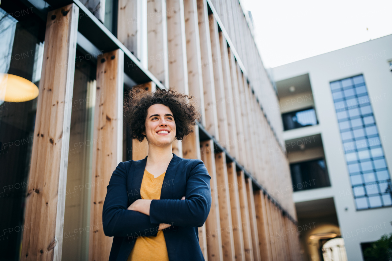 A happy young business woman standing outdoors, resting. Start-up concept.